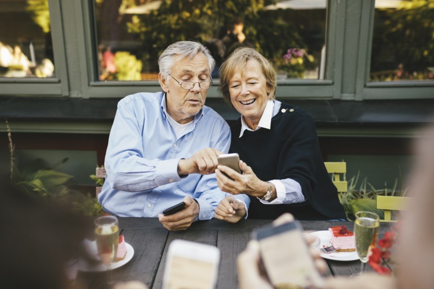 Eldre par som ser på telefonen sammen